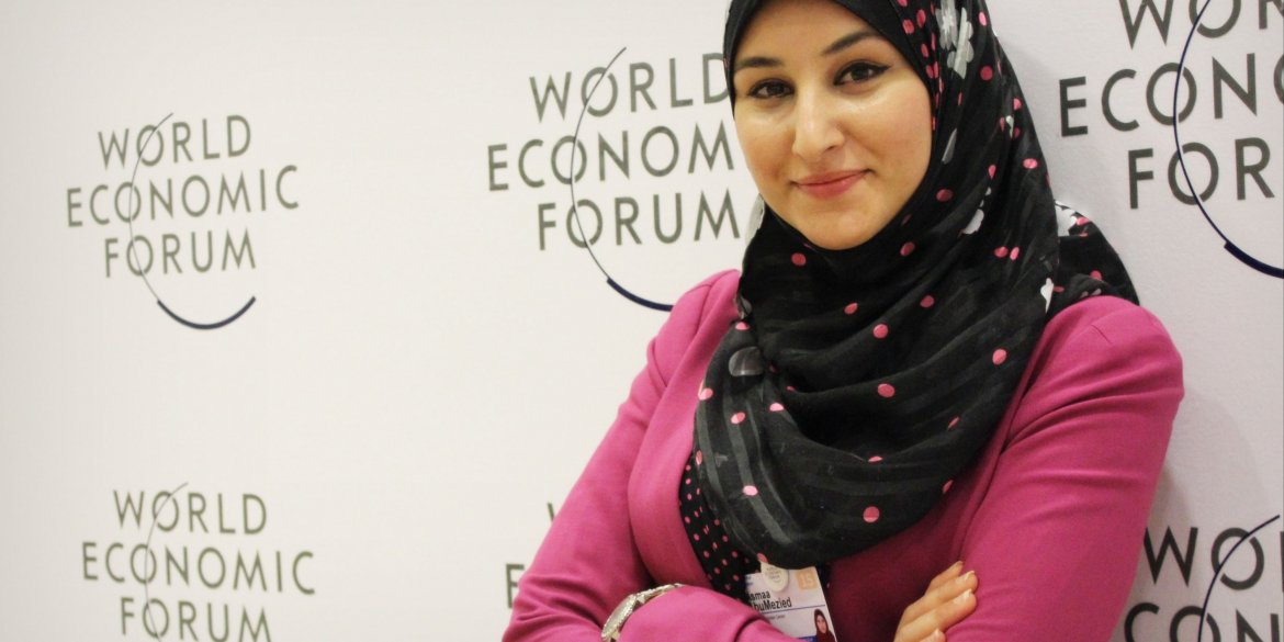 Woman in front of World Economic Forum poster