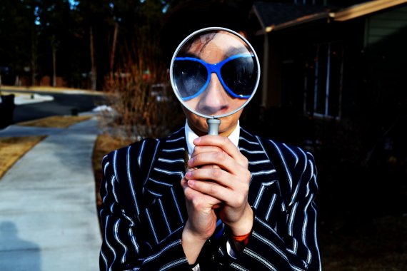person holding a magnifying glass in front of their face