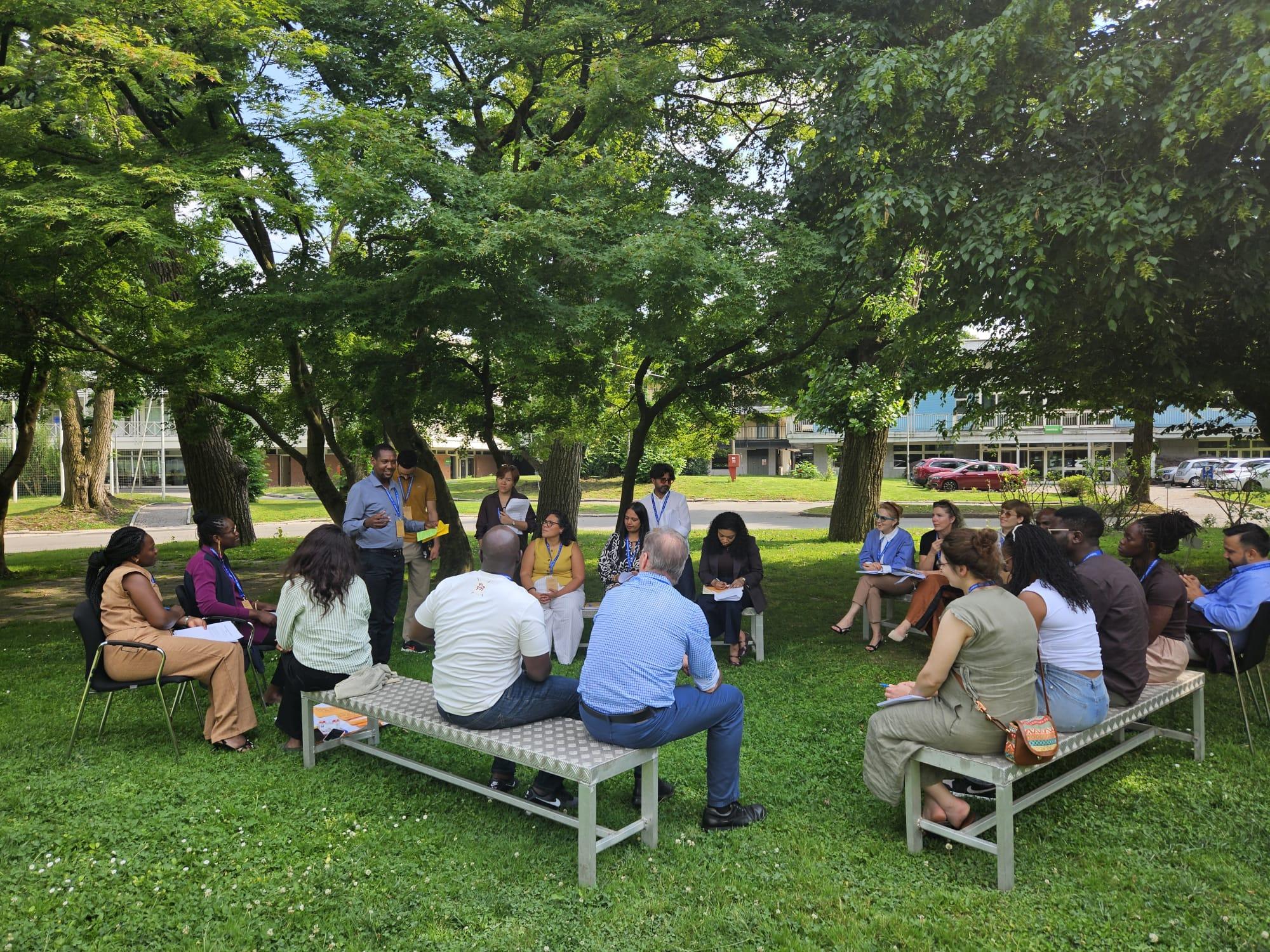 Participants sit in a circle outdoors on the Turin campus