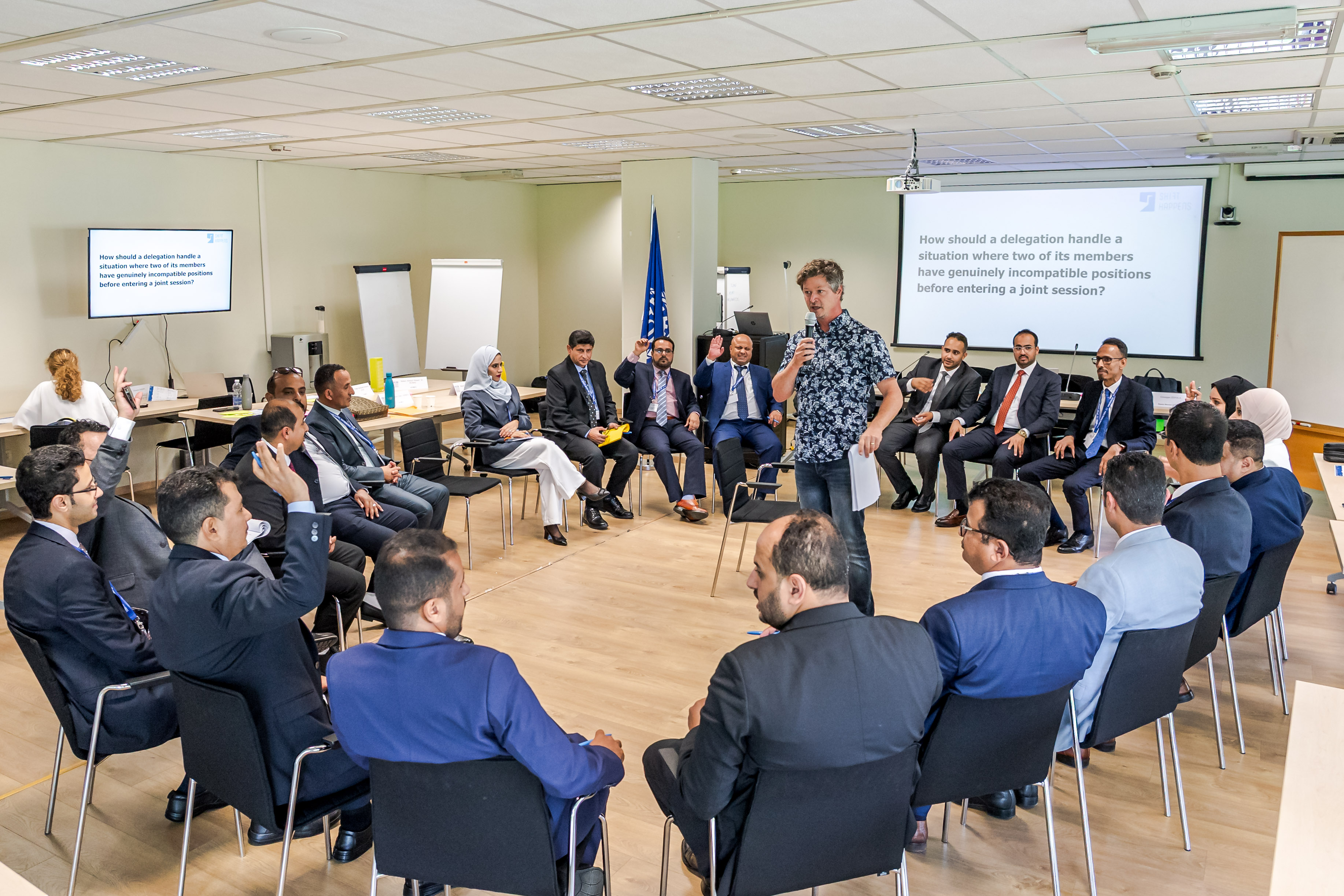 Participants seated in a circle in a meeting room while a facilitator leads the discussion.