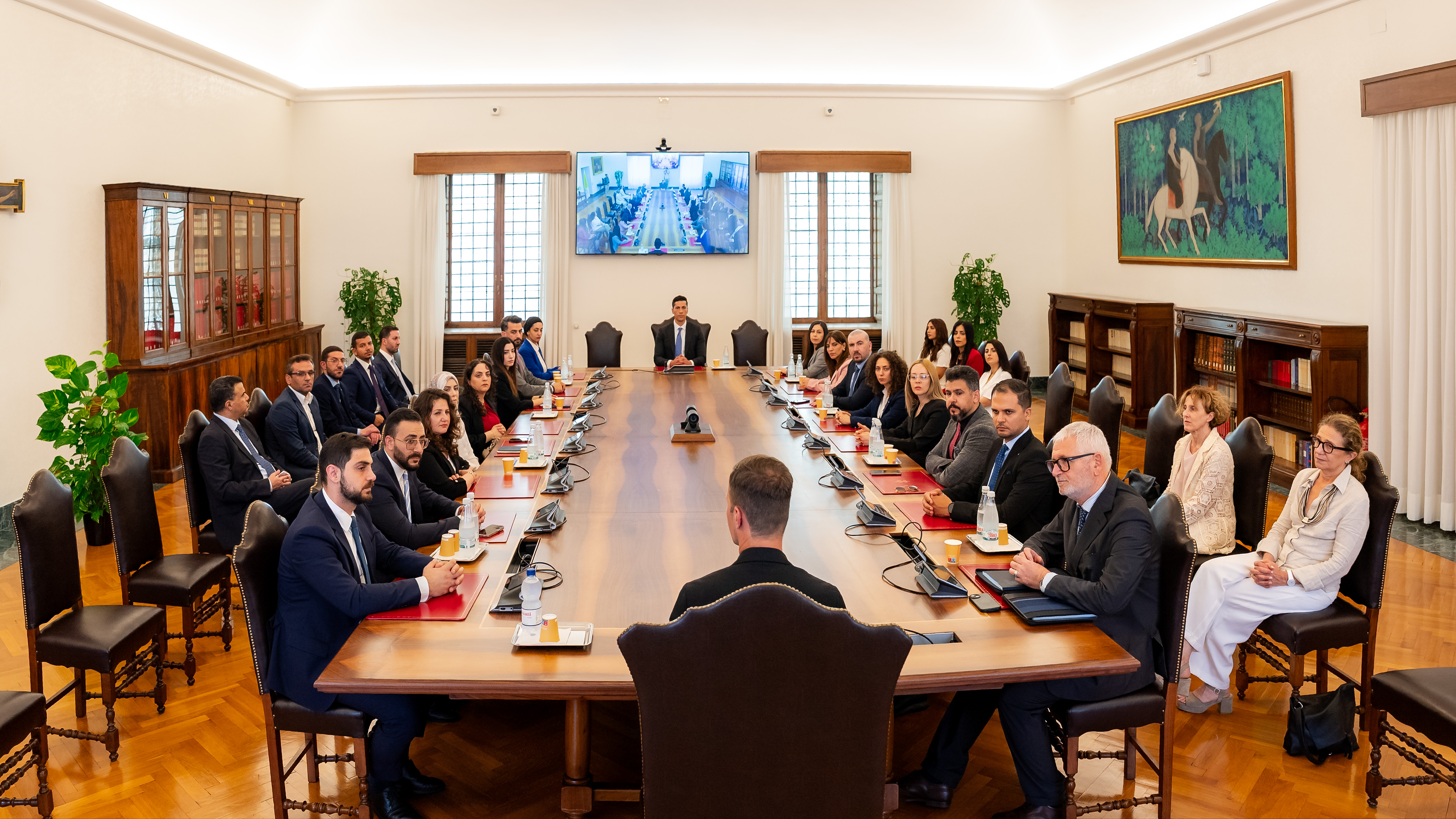 A group of diplomats and officials seated around a large conference table