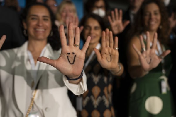 People smiling with smiley faces drawn on their hands