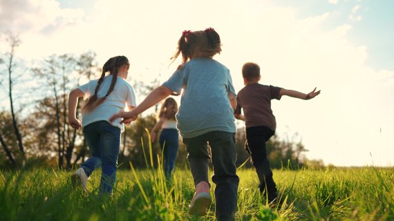 image of children running in a grass