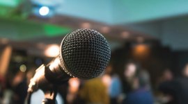 close up of a microphone in a room full of people