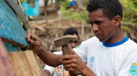 man using a hammer to construct a roof