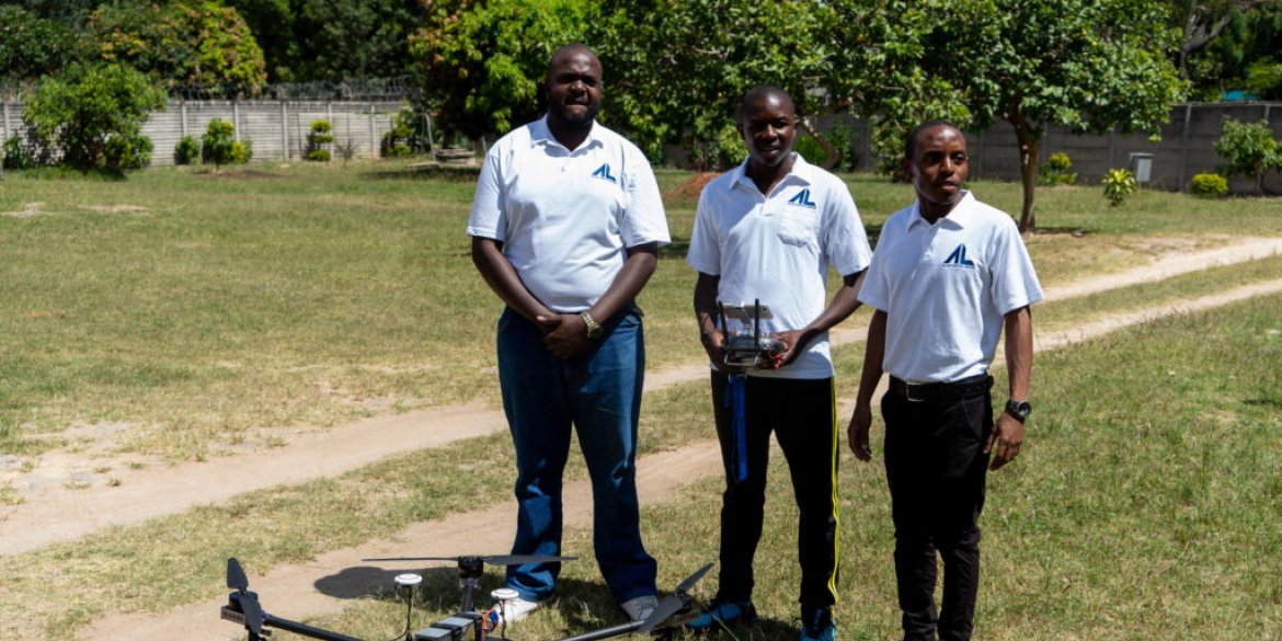 Three men behind a drone