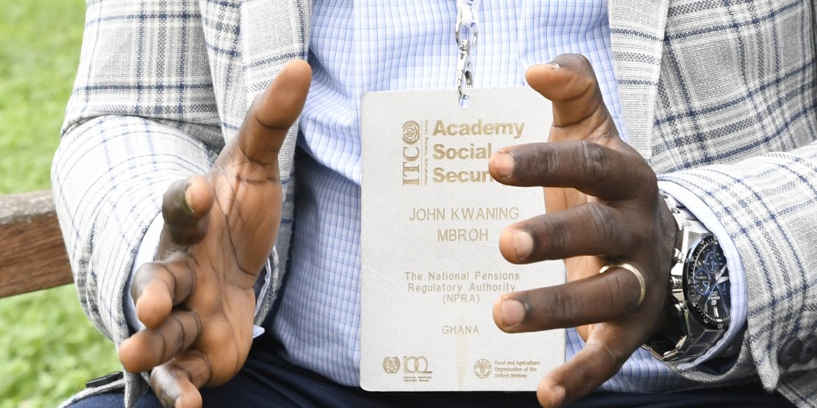 Focused shot on the hands of the participant and his name tag. 