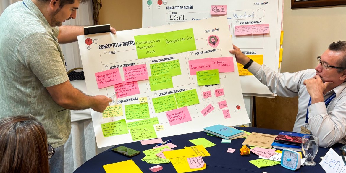 Participants work together on a group exercise, arranging colourful sticky notes on a large poster during an interactive workshop.