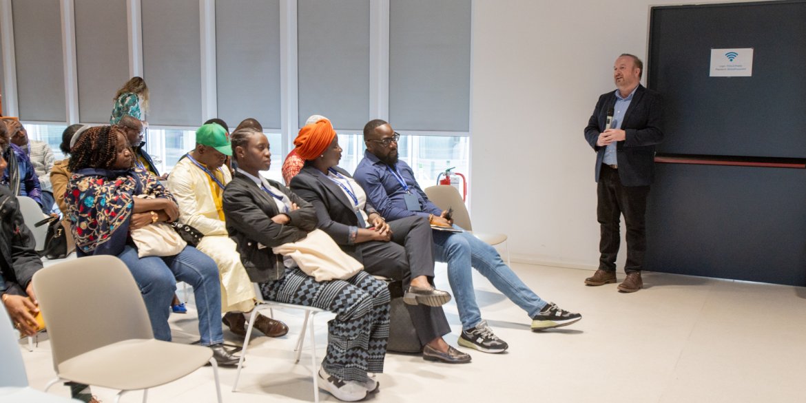 Participants are seated listening attentively to a facilitator 