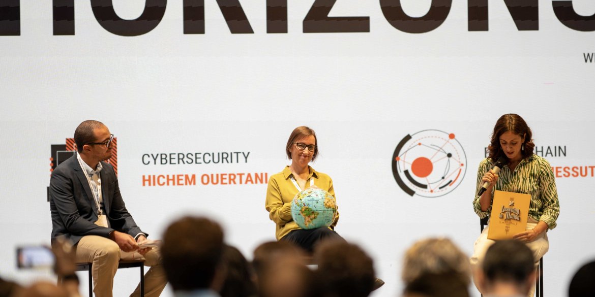 panel discussion on geospatial data, cybersecurity and blockchain during Innovation Day 2026, with three panellists seated on stage before an audience.
