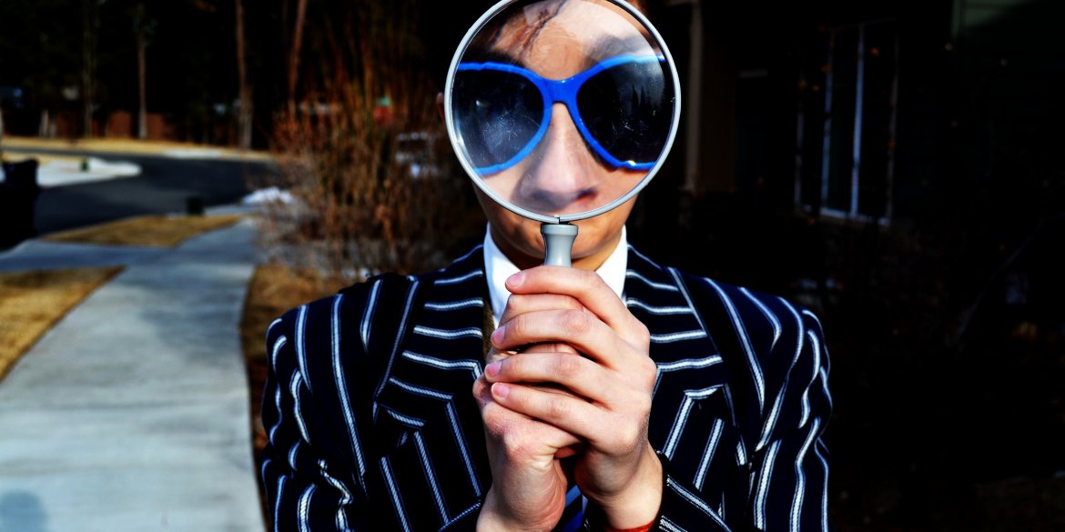 person holding a magnifying glass in front of their face