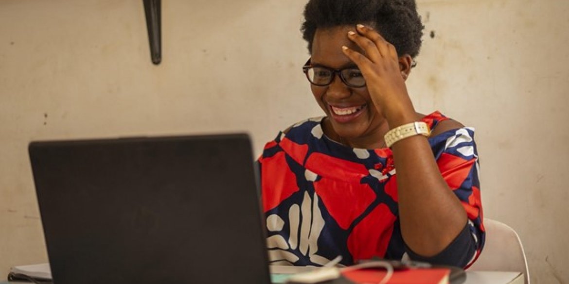 woman laughing and smiling at laptop