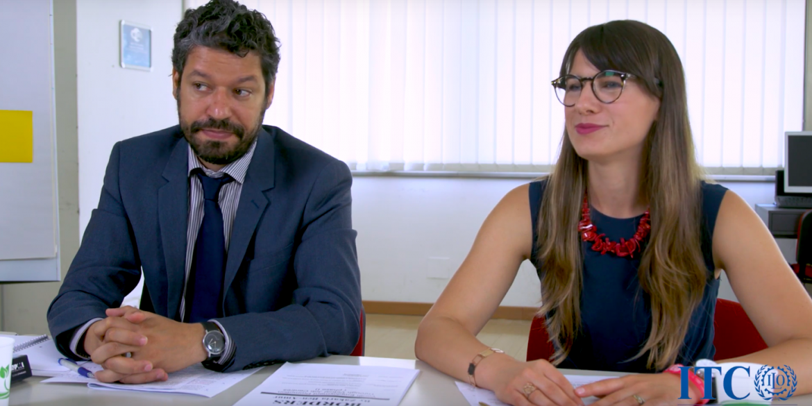 Two people talking at a desk