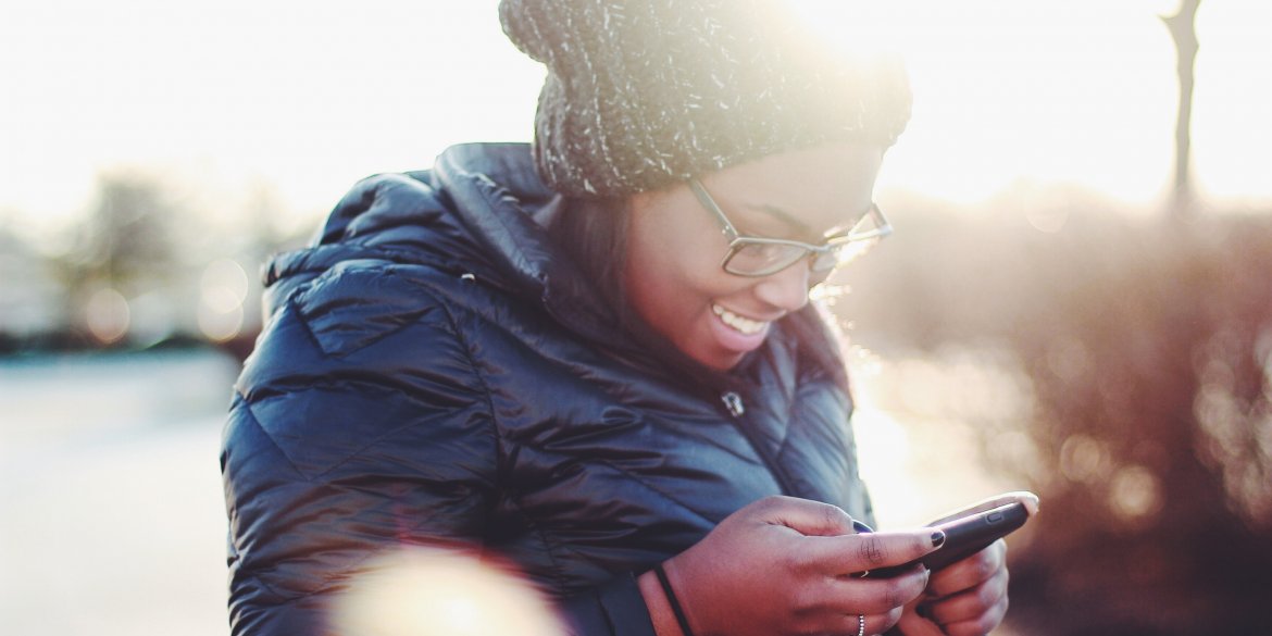 woman looking happily at her phone