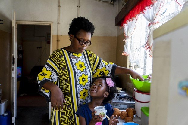 woman in colorful dress with daughter looking up at her