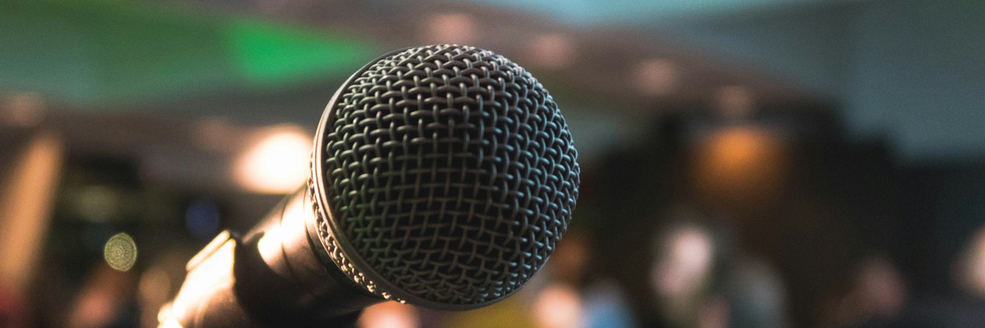 close up of a microphone in a room full of people