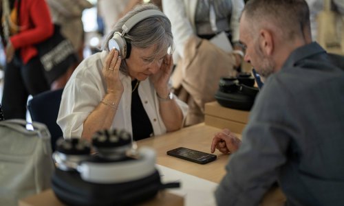 Participants at the ITCILO AI+ Nonference explore neurotechnology equipment during a hands-on demonstration, gathered around a table with headphones and digital devices.