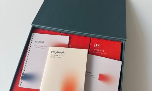 Open SENSIT toolkit box displaying the Playbook, Journal and red activity cards arranged inside.