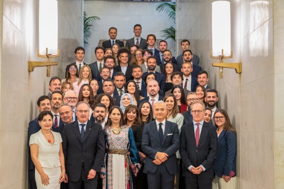 Group of delegates and officials pose for a formal group photograph on a staircase