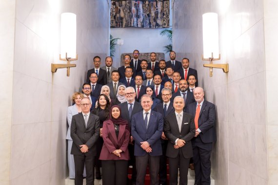 Group of delegates and officials pose for a formal group photograph on a staircase