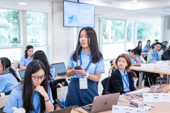 Chinese student dressed in a blue uniform speaking in a classroom