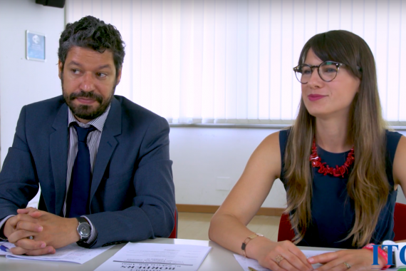 Two people talking at a desk