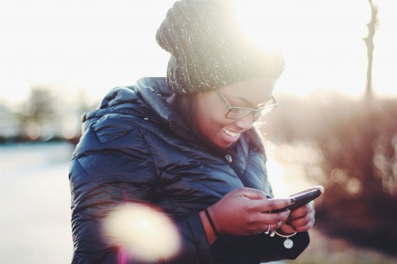 woman looking happily at her phone