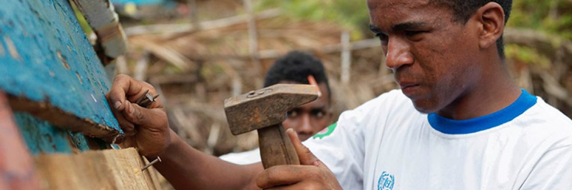 man using a hammer to construct a roof