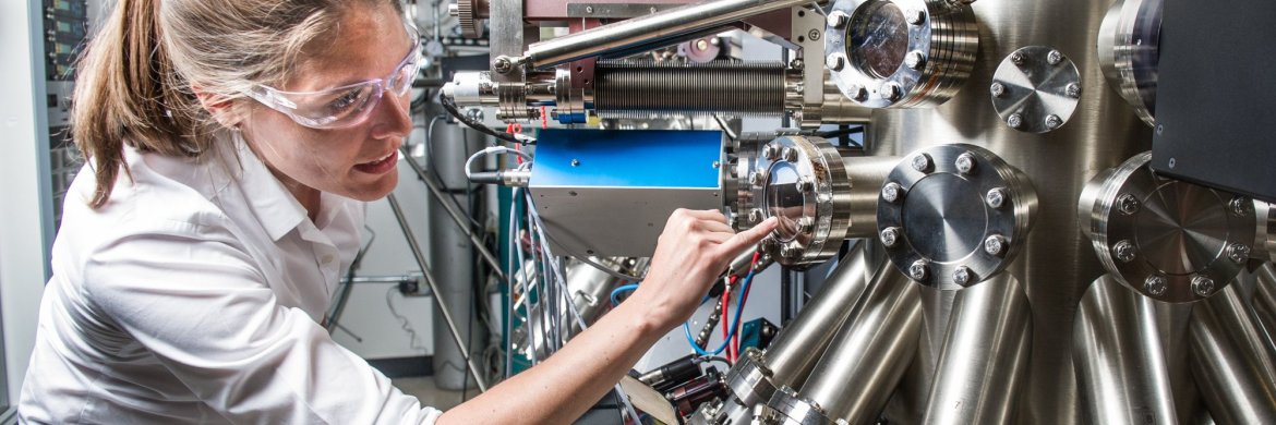 NREL scientist uses a Compound Semiconductor Molecular Beam Epitaxy System to grow semiconductor samples in the Semiconductor Growth lab at the Solar Energy Research Facility at NREL.